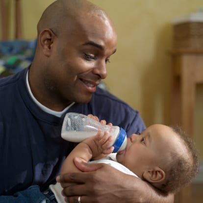 dad bottle feed breast milk to his baby